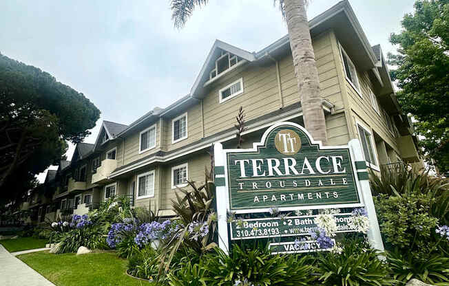A sign for Terrace Apartments is in front of a building.