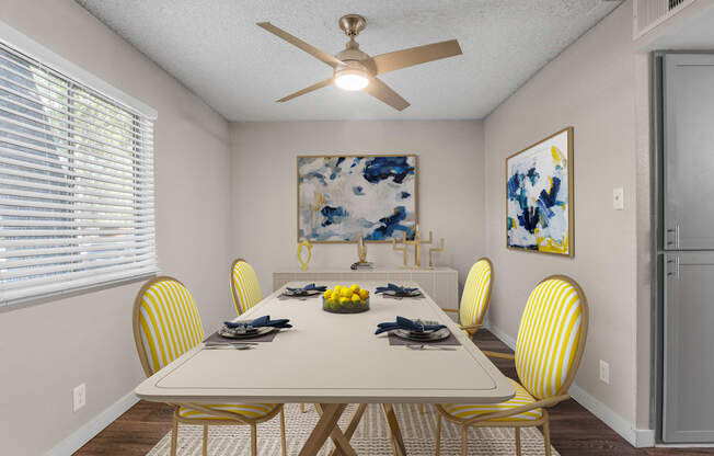 A dining room with a white table and yellow chairs.