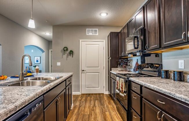 A kitchen with sink, stove, and closet door at the Flats at Sundown in North Port, Florida