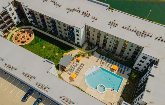 an aerial view of an apartment building with a swimming pool and a courtyard