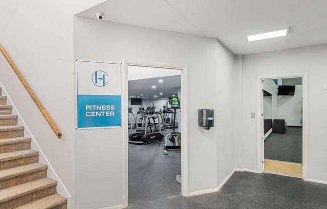 a fitness center with stairs and a door to a gym