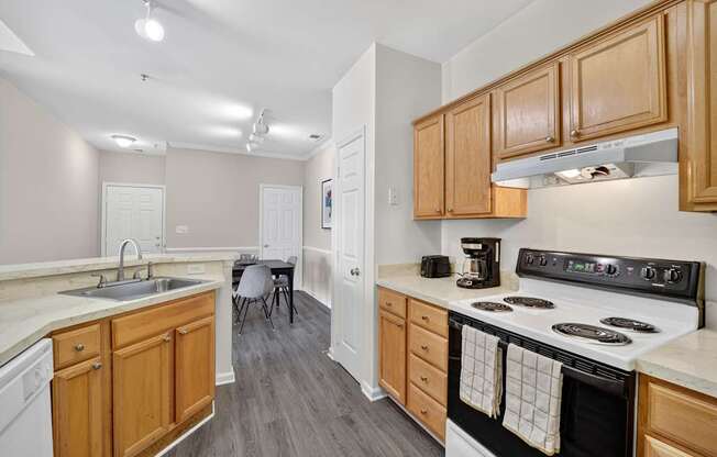 Kitchen in classic style apartment with wooden cabinets and a white stove top oven.