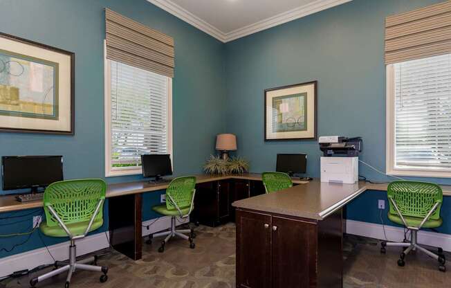 A room with blue walls and a desk with four chairs.