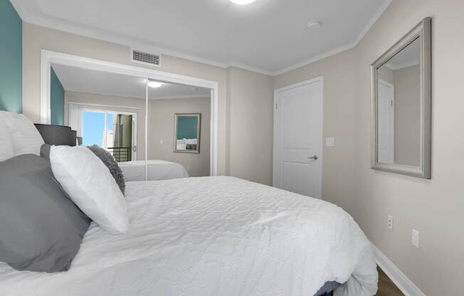 A bedroom with a large bed and a mirror on the wall.