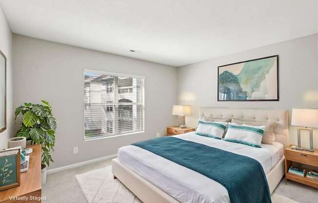 A bedroom with a large bed and a painting on the wall.