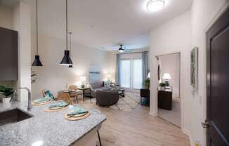 A modern kitchen with granite countertops and pendant lights.