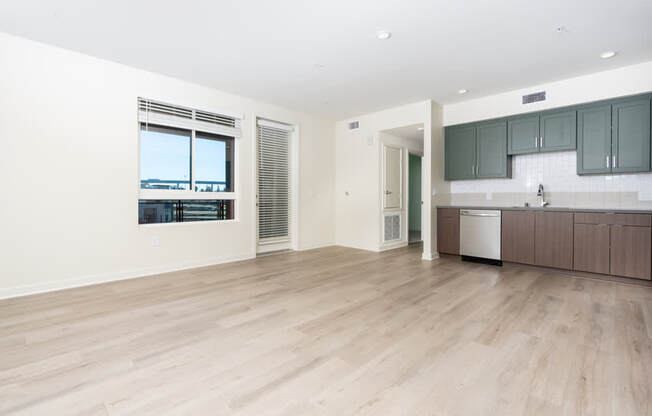 A kitchen area with a dishwasher and a window overlooking a body of water.