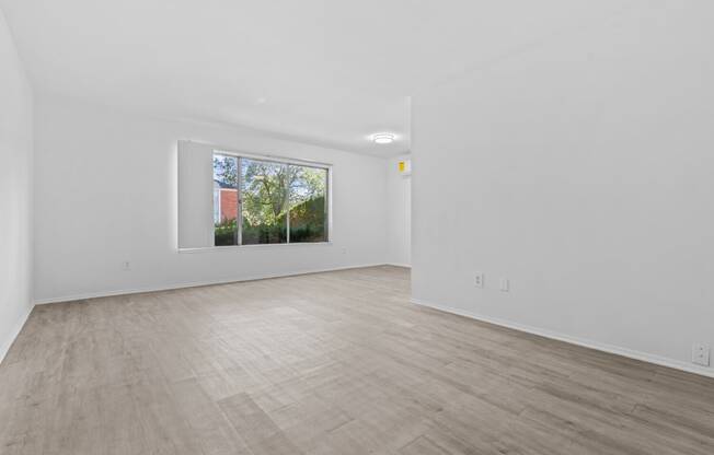 a bedroom with white walls and a large window