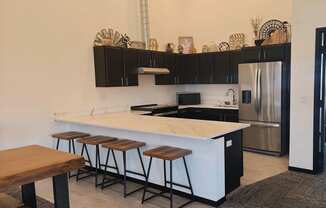 A kitchen with a white countertop and black cabinets.