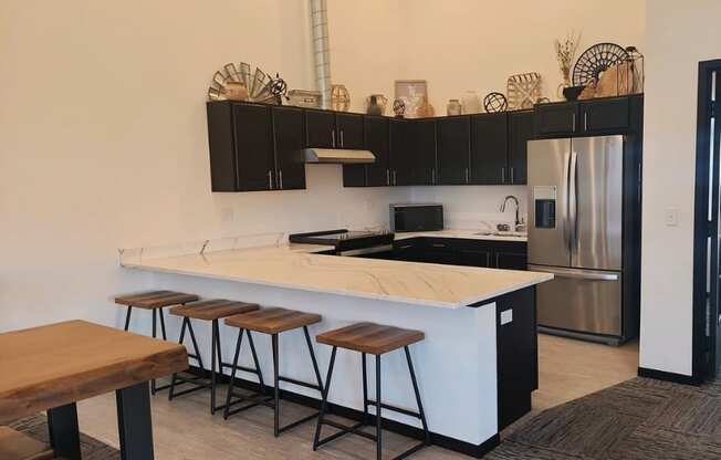 A kitchen with a white countertop and black cabinets.