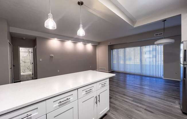 an empty kitchen with white counter tops and stainless steel appliances