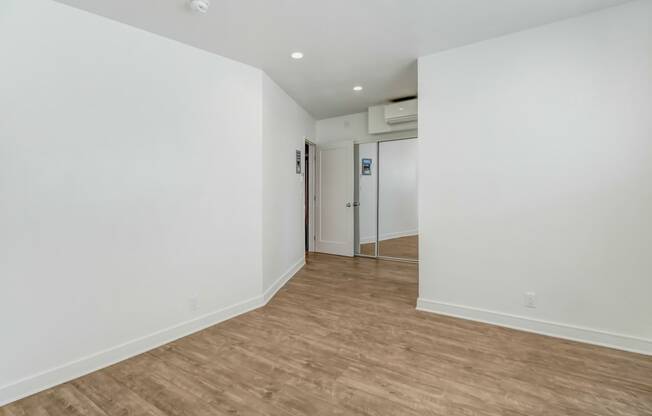 an empty room with white walls and a wooden floor