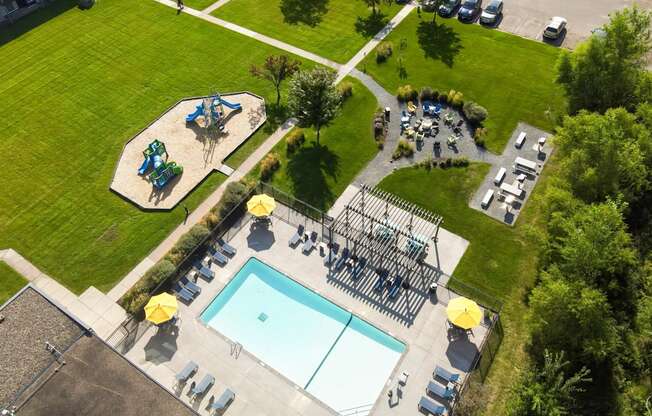 A playground with a slide, swimming pool and a play area.