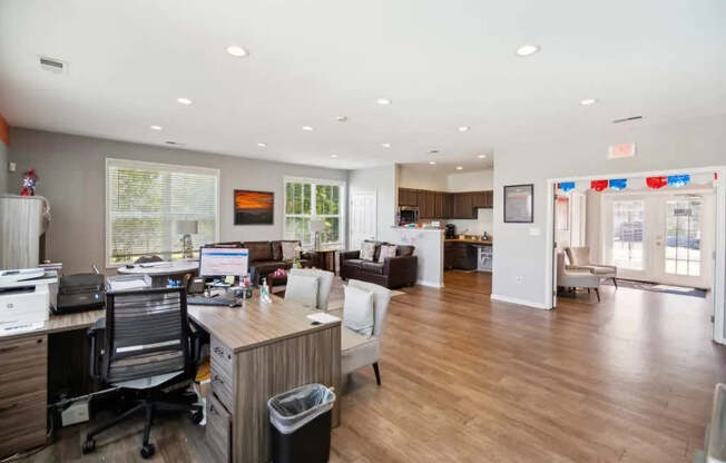 A spacious office with a wood desk and a black trash can.