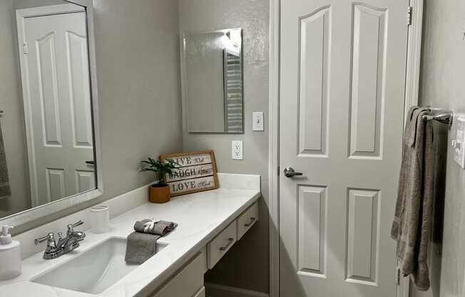 a bathroom with a sink and a mirror and a door