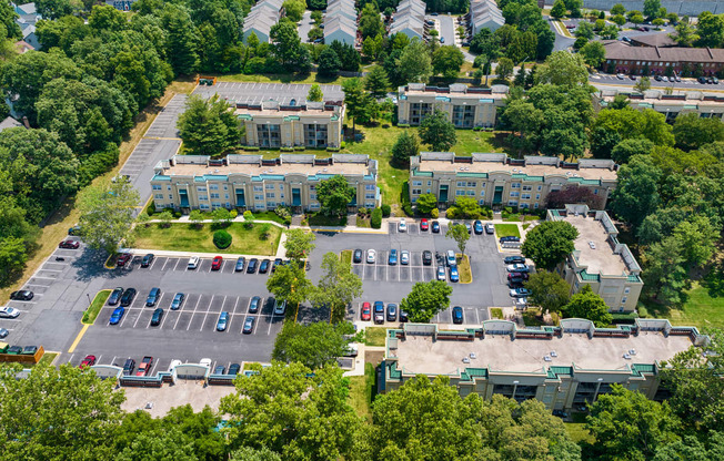 an aerial view of a parking lot with several buildings and trees