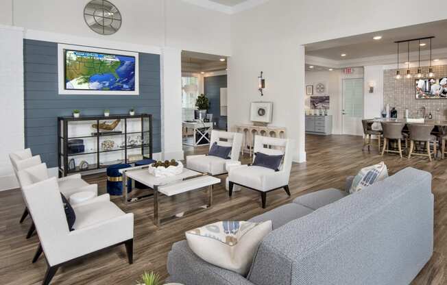 Resident clubhouse with sofas, chairs and large TV at at the Station at Savannah Quarters in Pooler, GA