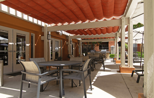 A patio with tables and chairs under a red roof.