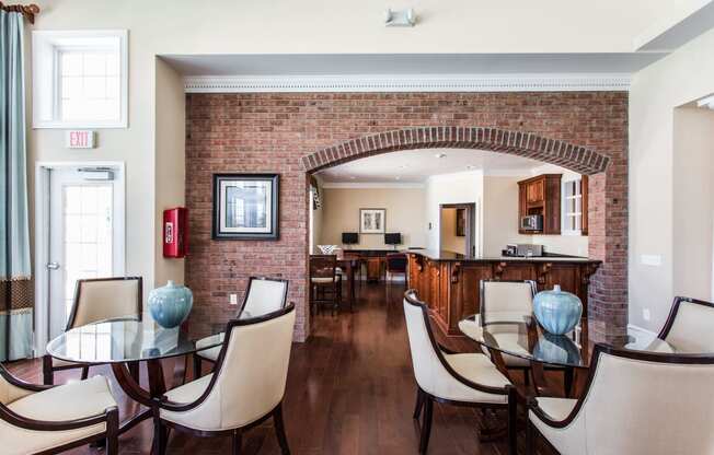 a dining room with a table and chairs and a brick wall