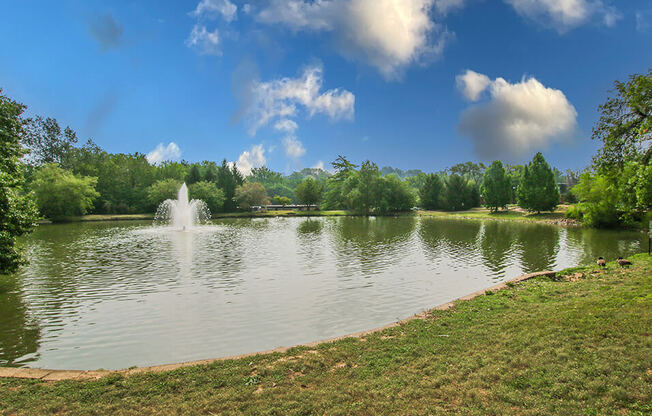 a fountain in the middle of a lake on a sunny day
