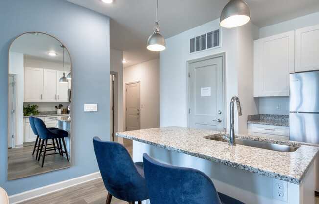 a kitchen with blue chairs and a marble counter top