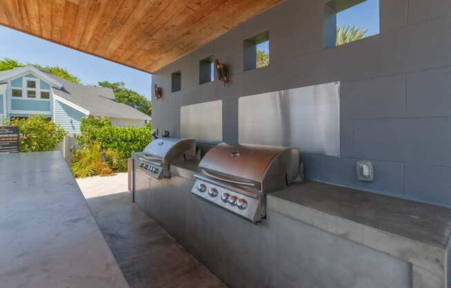an outdoor kitchen with a grill and a wooden ceiling at The Villages of Banyan Grove, Boynton Beach, FL, 33436