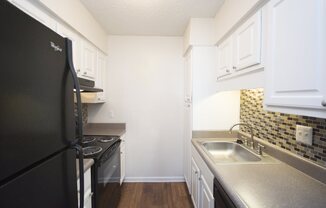 a kitchen with black appliances and white cabinets