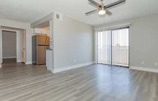 an empty living room with a ceiling fan