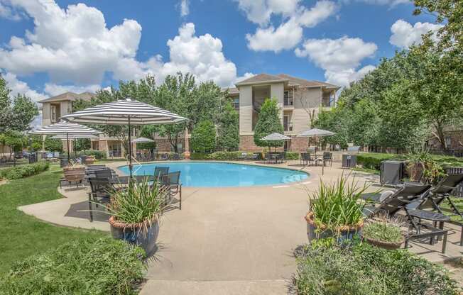 Affordable Houston Texas Apartments – Westchase Forest – Photo of a swimming pool with patio furniture and umbrellas