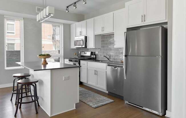 A modern kitchen with a large island and stainless steel appliances.
