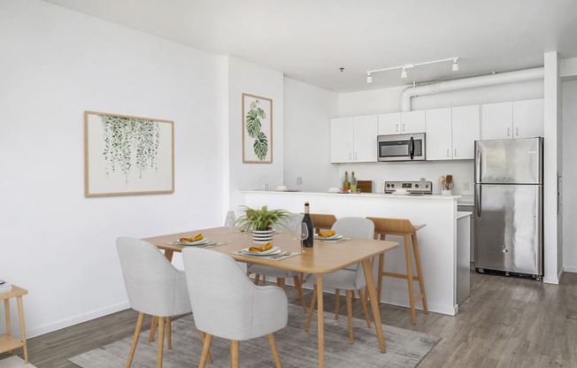 Studio Apartments in Southeast Portland, OR - The Lenox - Dining Area with a 4-Piece Dining Set, Luxury Wood Grain Vinyl Plank Flooring, and White Kitchen