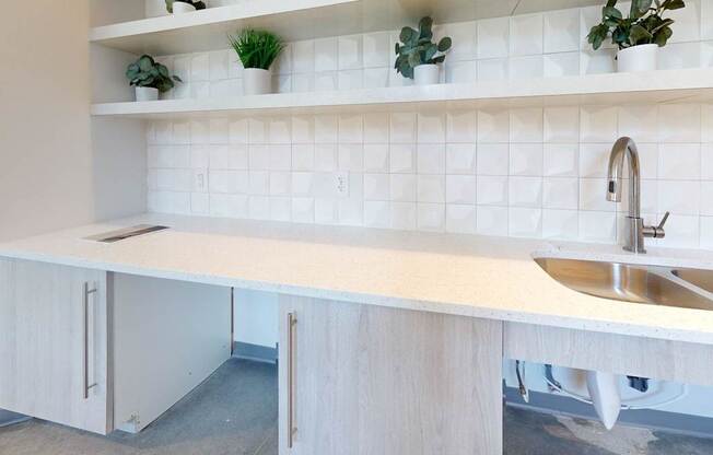 A white kitchen with a sink and a cabinet.
