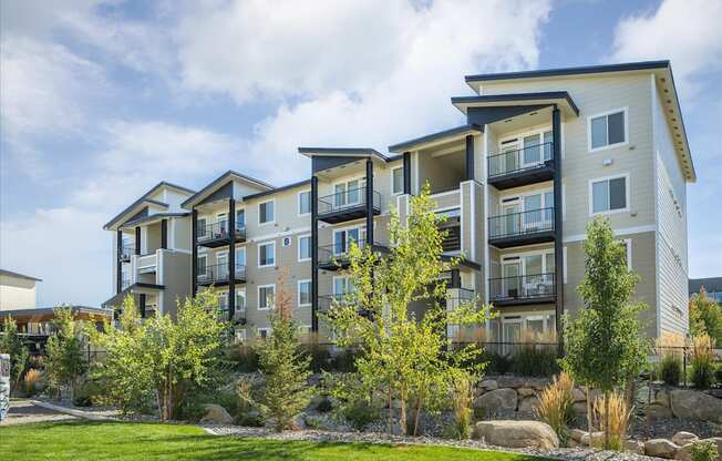 a row of apartment buildings with grass and trees