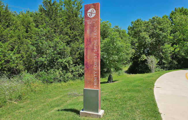 A signpost for the Honey Creek Trail stands in a grassy area.