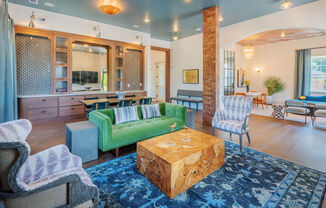 A living room with a green couch and a wooden coffee table.