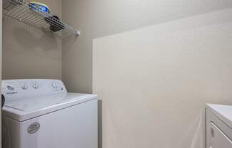 A white dryer is on the left in a small laundry room.