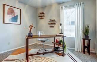 a home office with a ceiling fan and a window