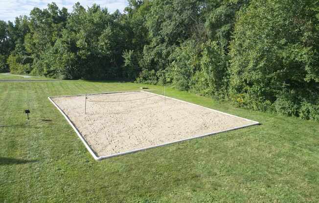 a tennis court in the middle of a grass field