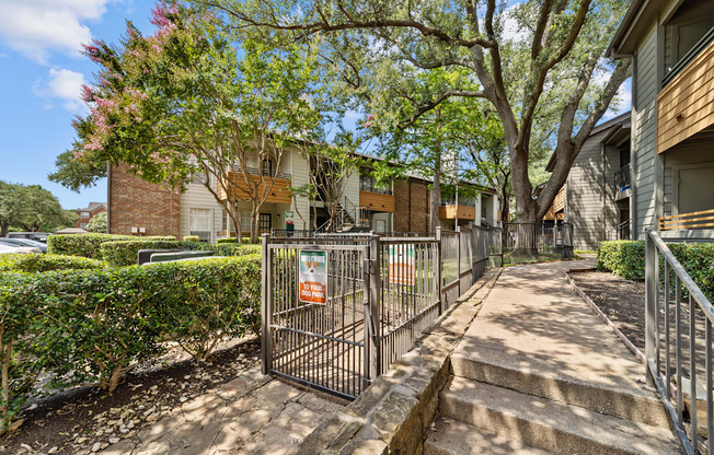 A gated entrance to a residential area with a sign on the gate.