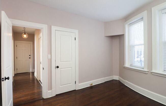 an empty living room with wood floors and a white door at The Packard, West Hartford, CT