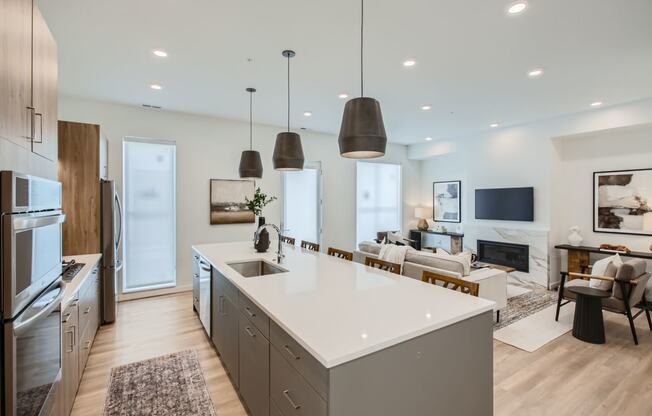 an open kitchen and living room with a white counter top