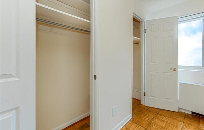 vacant bedroom with hardwood flooring, ceiling fan, window and view of closets at chillum place apartments in lamond riggs washington dc