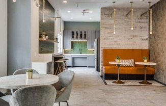 a dining area with tables and chairs and a kitchen in the background at Carrington at Barker Cypress, Cypress, TX