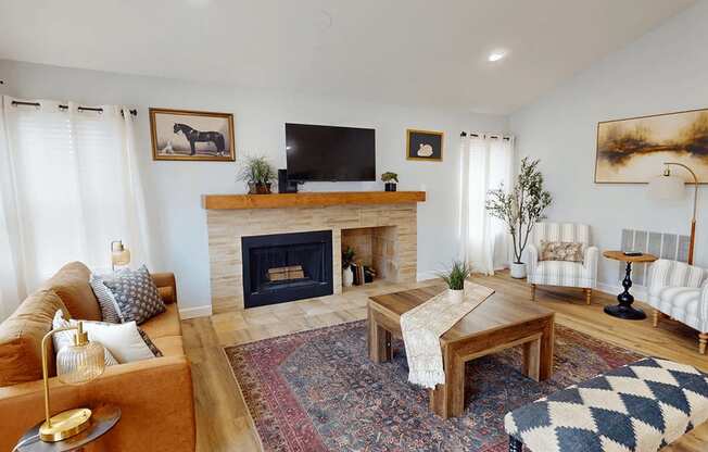 A living room with a fireplace and a television on the wall.