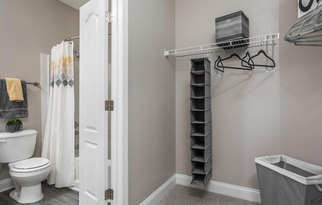 Oversized walk-in closet with shelving and clothing racks off of master bathroom