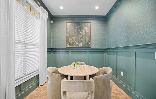 A dining room with a round table and chairs.