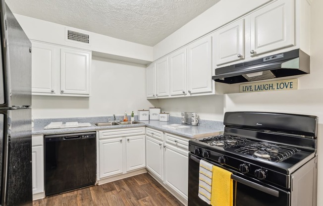 A kitchen with white cabinets and a black stove top oven.