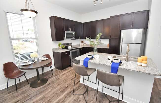 a kitchen with a breakfast bar and a table with chairs