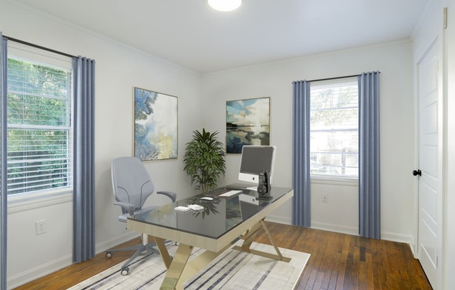 a home office with white walls and wood floors at Ann Street Lofts, Mobile, AL