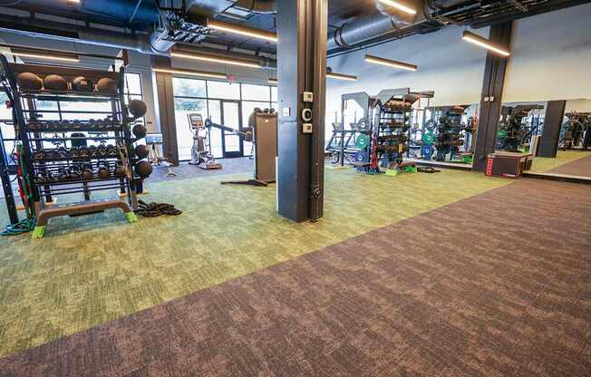 A gym with a variety of equipment including weights and cardio machines.